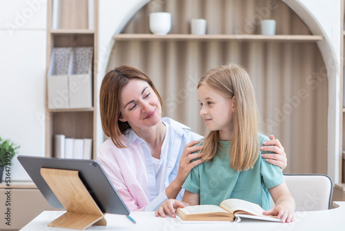 Wallpaper Mural Young mother and daughter doing homework together. Preparation for school and online education concept Torontodigital.ca