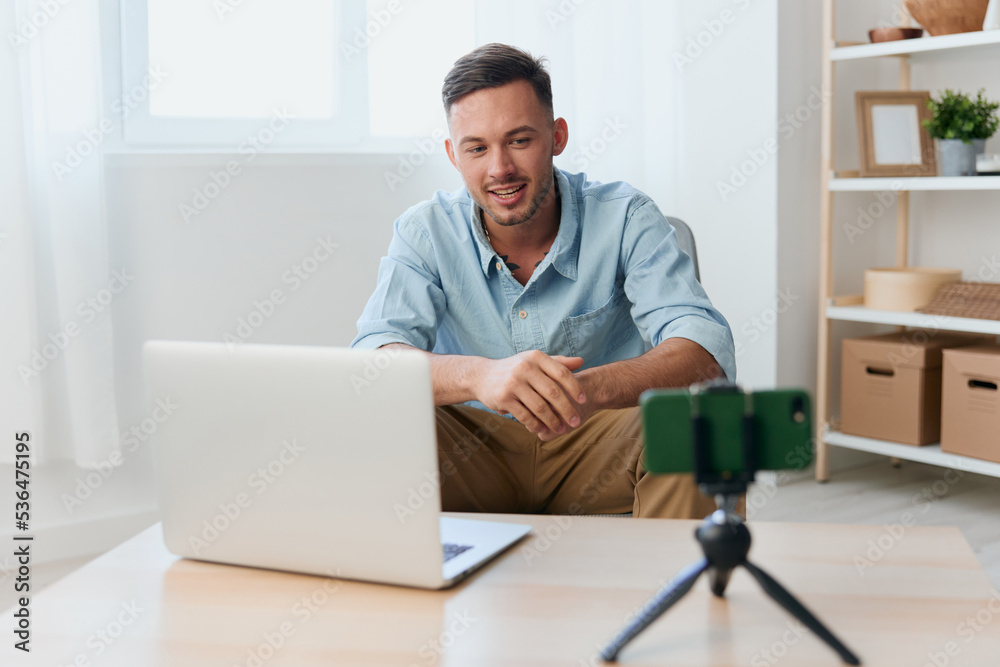 Excited happy enjoyed talking with subscribers attractive young blogger investor record video at phone camera using laptop. Copy space for ad. Remote Job, Technology And Career Profession Concept Excited happy enjoyed talking with subscribers attractive young blogger investor record video at phone camera using laptop. Copy space for ad. Remote Job, Technology And Career Profession Concept