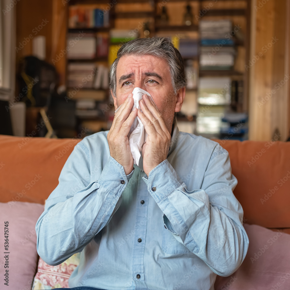 Sick man with a cold and sneezing through the cold of winter in his house. Sick man with a cold and sneezing through the cold of winter in his house.