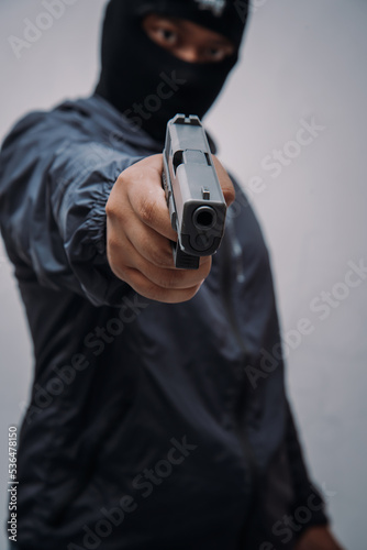 Burglar or terrorist. Holding pistol in various poses on background isolated with clipping path.