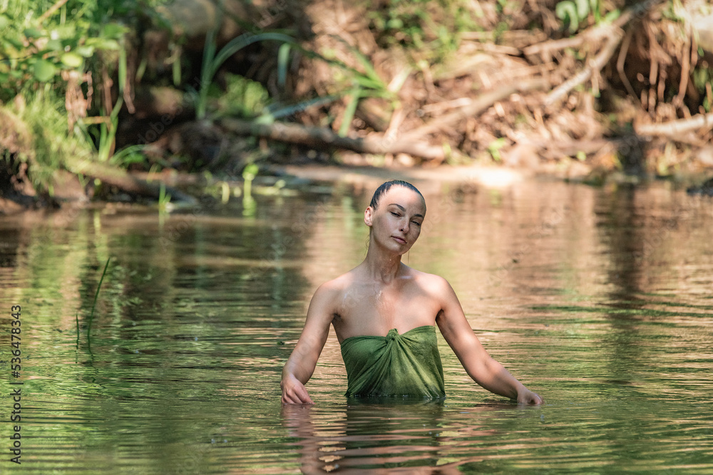 Portrait of a young beautiful dark-haired girl posing in the river. Portrait of a young beautiful dark-haired girl posing in the river.