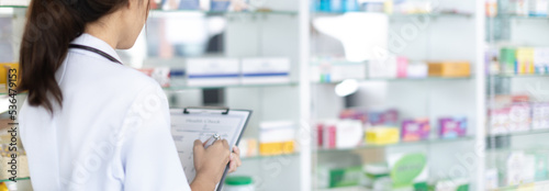 Pharmacist working in a pharmacy  Consultation and medical advice  All kinds of generic household drugs and pharmaceutical products on the shelf  Service and assistance to patients  Pharmacy.