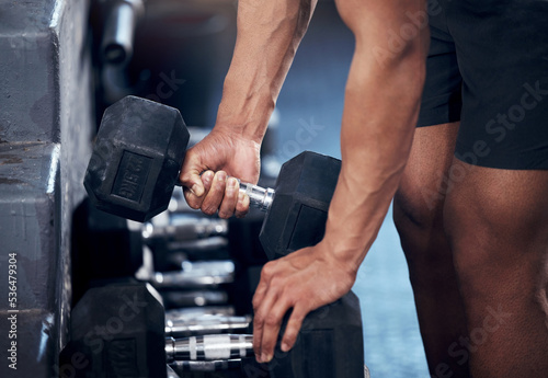 Closeup of man, workout and hands weightlifting with dumbbell in gym for health, fitness and muscle development. Strong, bodybuilder and exercise for sports, wellness and motivation in training club
