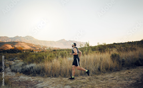 Fototapeta Naklejka Na Ścianę i Meble -  Man running in nature, marathon fitness training exercise and healthy sunrise cardio workout. Sports runner, racing on hiking path and working out for athletic speed or energy in race competition