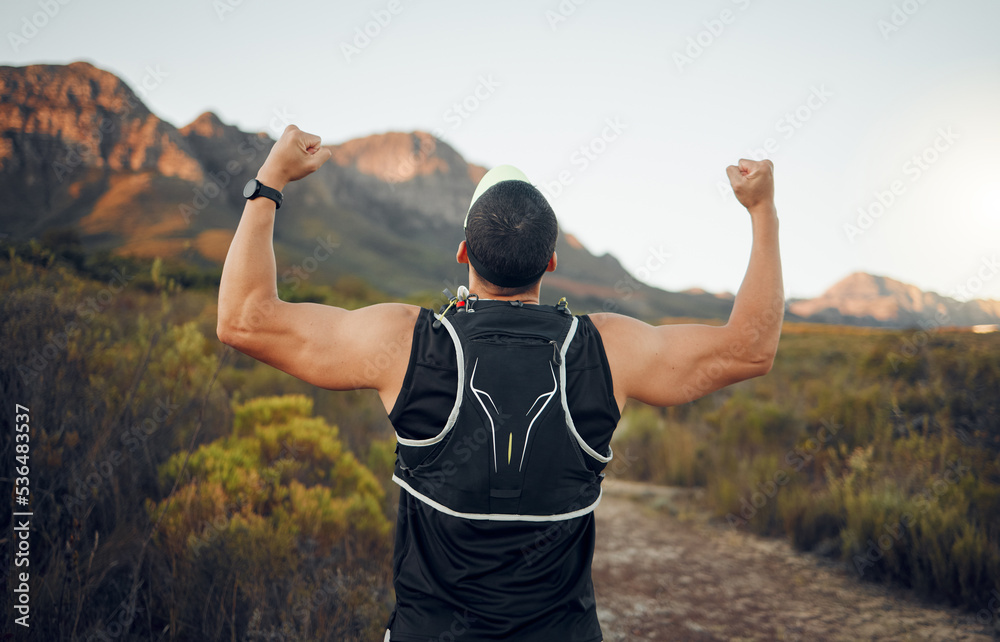 Fototapeta premium Winner, mountain and runner man success with back view celebrating cardio exercise goal victory. Muscular, strong and fitness lifestyle male running achievement celebration in South African bush.