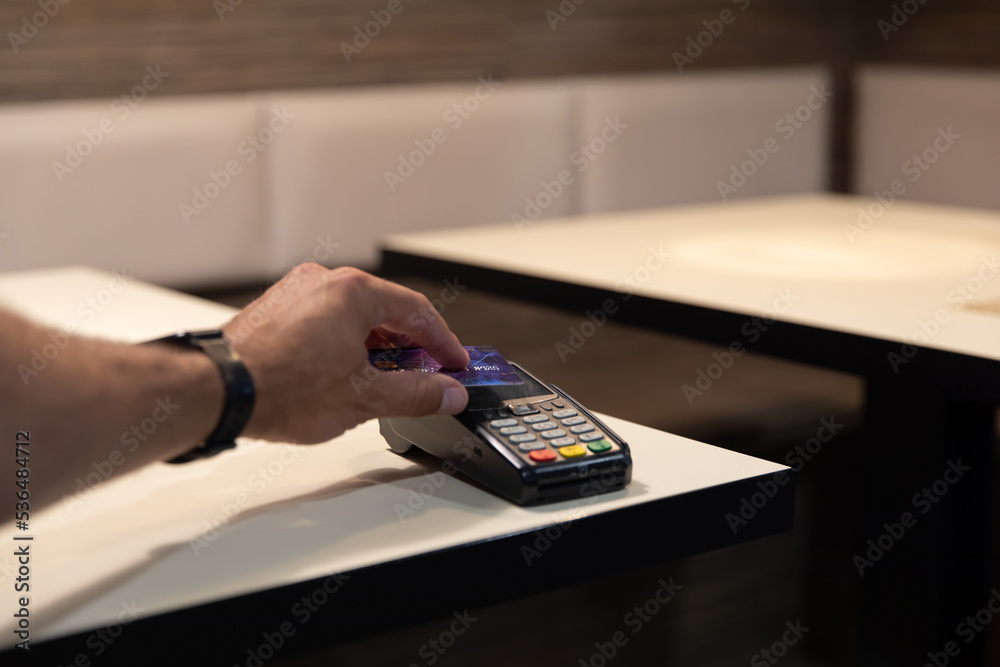 Credit card payment. A young man makes a payment with a credit card.