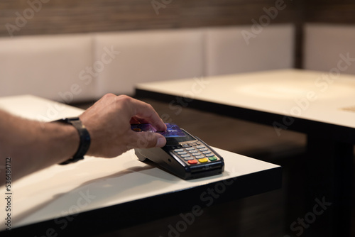 Obraz na płótnie Credit card payment. A young man makes a payment with a credit card. w salonie