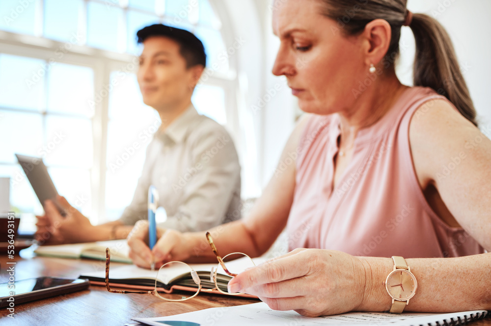 Business woman, focus and planning in meeting in office and workplace writing notes for collaboration project. Team, female and mature lady with ideas, inspired or brainstorming strategy at workspace
