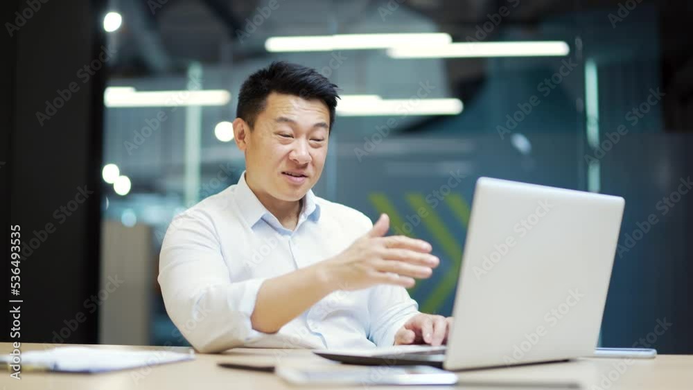 Asian male employee communicates remotely online via video call while sitting in office using laptop computer. Business man hold meeting, conferences, talks with partners colleagues at the workplace Asian male employee communicates remotely online via video call while sitting in office using laptop computer. Business man hold meeting, conferences, talks with partners colleagues at the workplace