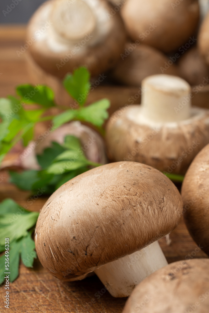 Macro closeup of portobello mushrooms on wooden table with parsley, selective focus, vertical Macro closeup of portobello mushrooms on wooden table with parsley, selective focus, vertical
