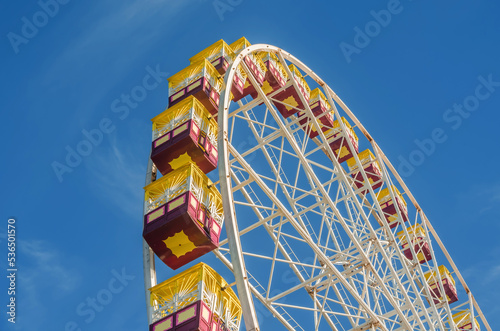 Ferris wheel gondolas against a blue sky