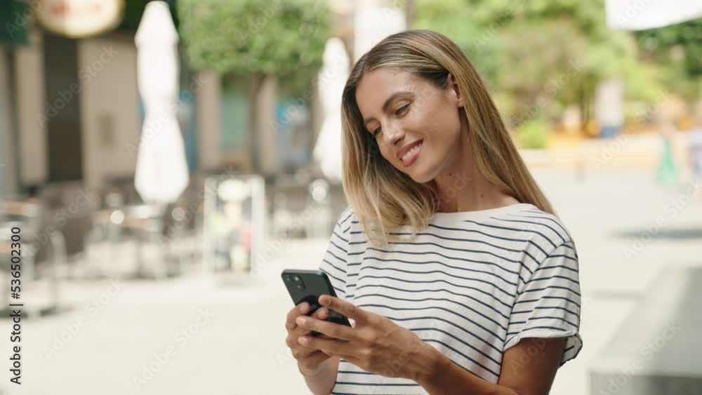 Young blonde woman smiling confident using smartphone at street Young blonde woman smiling confident using smartphone at street