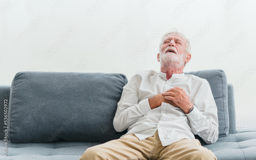 Senior male asian suffering from bad pain in his chest heart attack at home. Senior heart disease. Man with chest pain suffering from heart attack at home