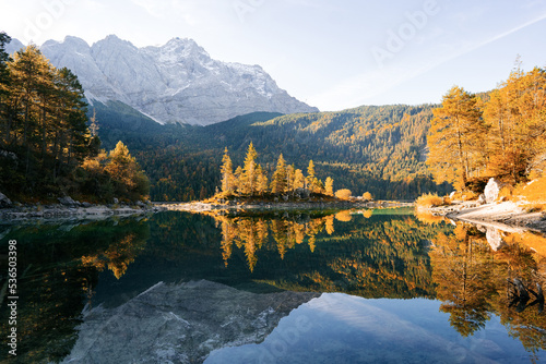 Small islands on the lake with fall colours and beautiful reflections. 
The beautiful scenery of Eibsee Lake with Zugspitze Mountains in Bavaria, Germany during autumn photo