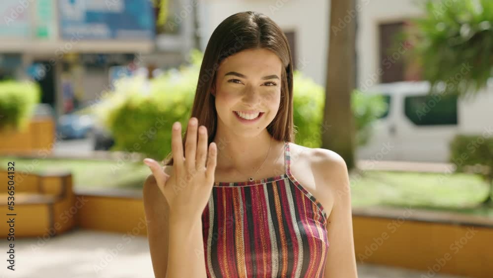 Young beautiful hispanic woman smiling confident doing coming gesture with hand at park Young beautiful hispanic woman smiling confident doing coming gesture with hand at park
