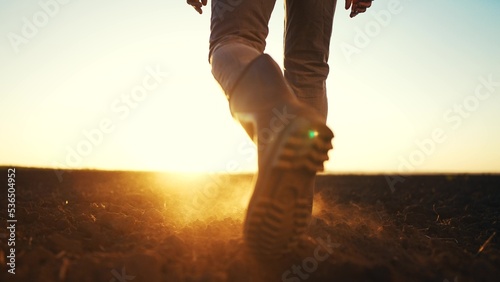 Fotografia farmer feet walks across a black field