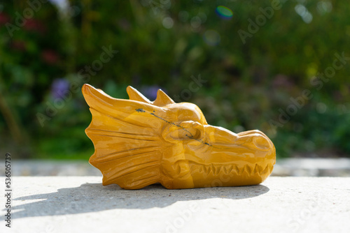 Dragon statue near house in front of garden.