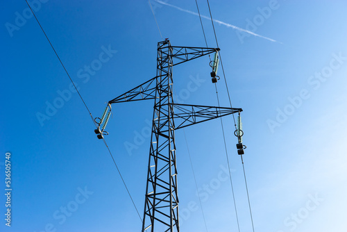 Electrical high voltage pylon with blue sky in background.