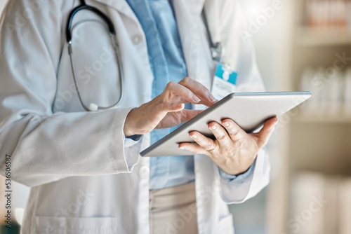 Doctor, office and tablet for research, email or communication. Medic, hospital and reading article, data or health magazine on web, while working with technology in healthcare center or clinic photo