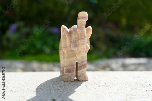 Elephant statue near house in front of garden.