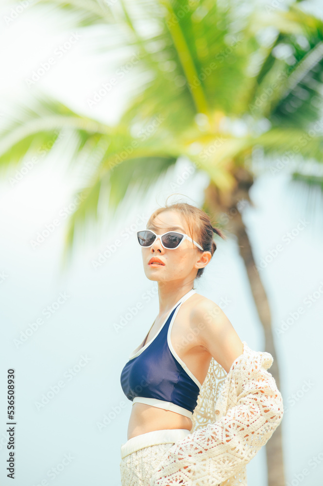Woman enjoying beach relaxing joyful in summer, girl on vacation wearing sun glasses.