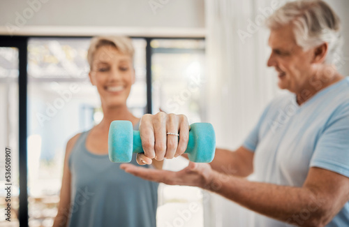 Elderly, couple and training in home for health, motivation and fitness. Retirement, woman and man teaching in weightlifting workout in living room for wellness, exercise and healthy lifestyle