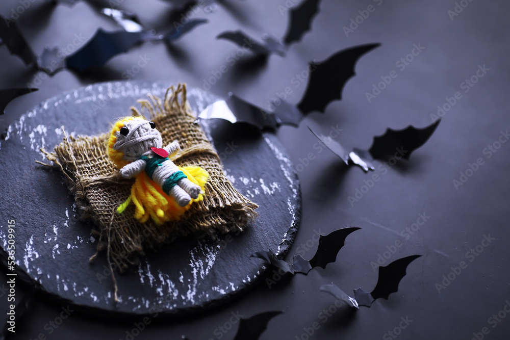 Halloween holiday concept. Old stone table in a shape of bats. Halloween paper decorations on dark background. Moon toy.