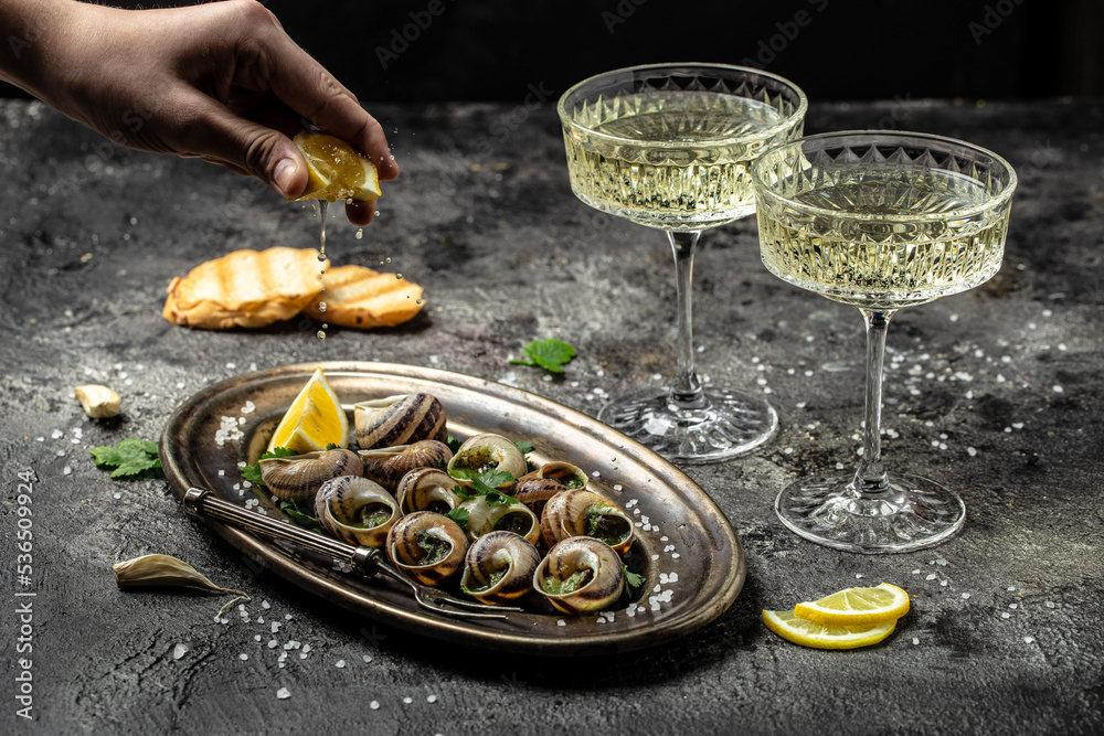 Baked snails with butter and spice on dark background. Snails baked with sauce, Bourgogne Escargot Snails. gourmet food. concept of french cuisine, Long banner format. top view