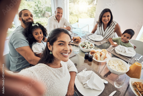 Big family selfie while eating food or lunch together in their home dining room table with a portrait smile. Happy Puerto Rico parents  mother and father with children for digital holiday memory