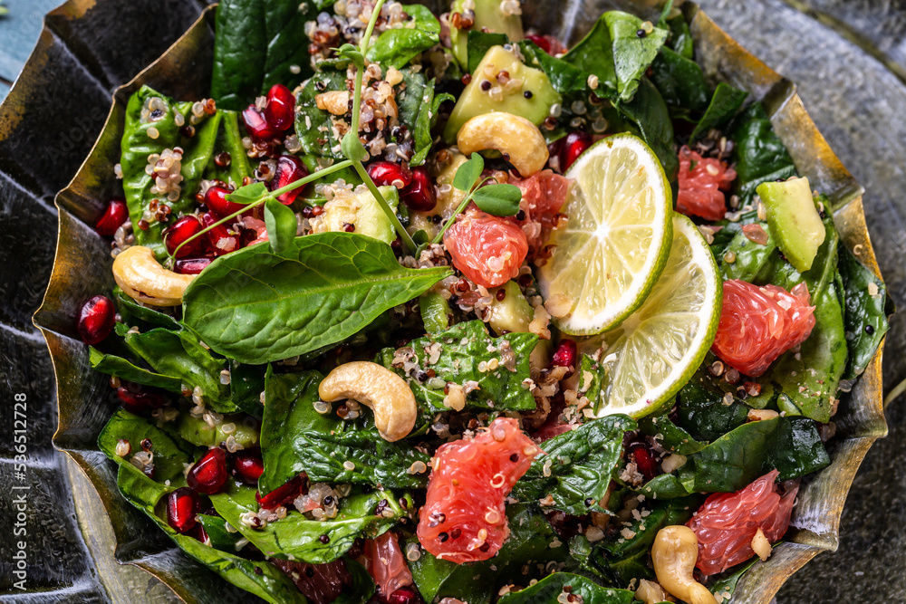 Vegan salad with quinoa, spinach, avocado, grapefruit, pomegranate, nuts and microgreens, Delicious breakfast or snack, Clean eating, dieting, vegan food concept. top view
