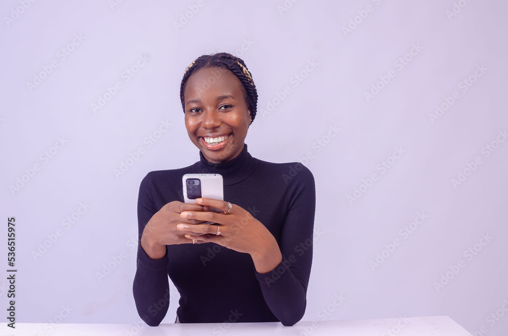young black woman using her phone with a smiling young black woman using her phone with a smiling