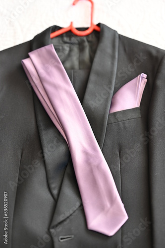 Mens dress up for Prom or a wedding with a shallow depth of field. purple being the main color with a suit and a tie with black shoes 