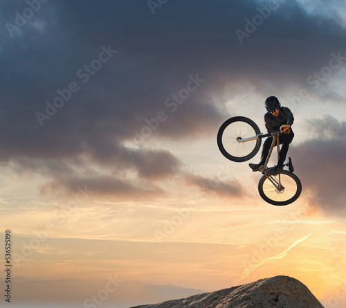 Mountain bike, jump and sport with mockup of a man athlete with energy and speed in nature. Healthy sports person with speed jumping and cycling with his bicycle at sunset on mountains with mock up