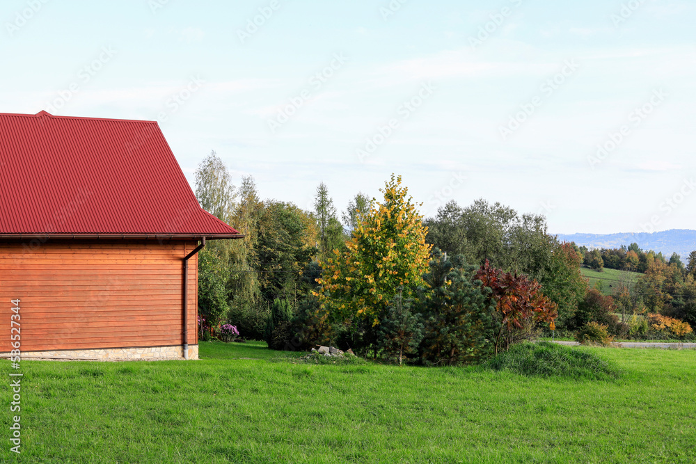 The red roof of an old wooden house made of sheet metal. The red roof of an old wooden house made of sheet metal.