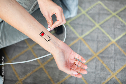 Close up of arm with low charge sensor on it and connecting with adapter for illustration needs of energy