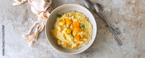 a plate of millet porridge with pumpkin on a light table
