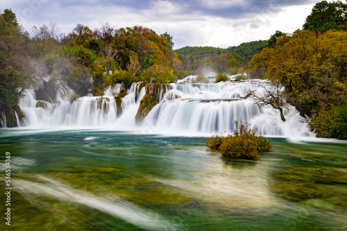 Krka National Park during colorful autumn travel destination in Dalmatia  Croatia  Europe. Fall colors leafs on trees. Krka Waterfalls and water in sunny morning light with fog. Landscape photography.
