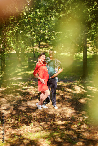 Lovely pregnant couple walking in a park
