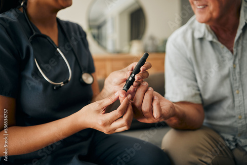 Blood test, doctor consultation and senior man consulting with healthcare nurse about diabetes. Hands of elderly person and hospital worker doing check on sugar with insulin pen on the sofa of home