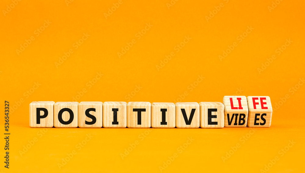 Positive vibes and life symbol. Concept words Positive vibes or Positive life on wooden cubes. Beautiful orange table orange background. Business positive vibes life concept. Copy space Positive vibes and life symbol. Concept words Positive vibes or Positive life on wooden cubes. Beautiful orange table orange background. Business positive vibes life concept. Copy space