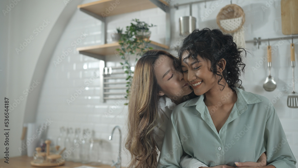 Fototapeta premium Holiday concept of 4k Resolution. Asian women embracing each other in the kitchen. Young women are in a mutual lesbian love relationship.