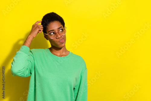 Portrait of attractive skeptic girl making decision copy space isolated over bright yellow color background photo