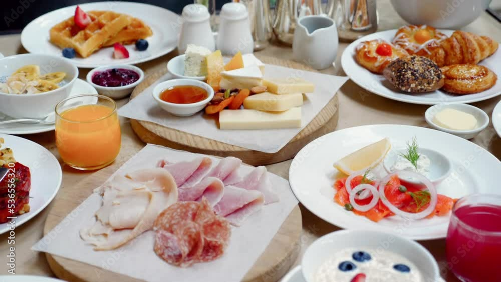 Table full of delicious food - cheese, salmon, ham, bakery and juices Table full of delicious food - cheese, salmon, ham, bakery and juices