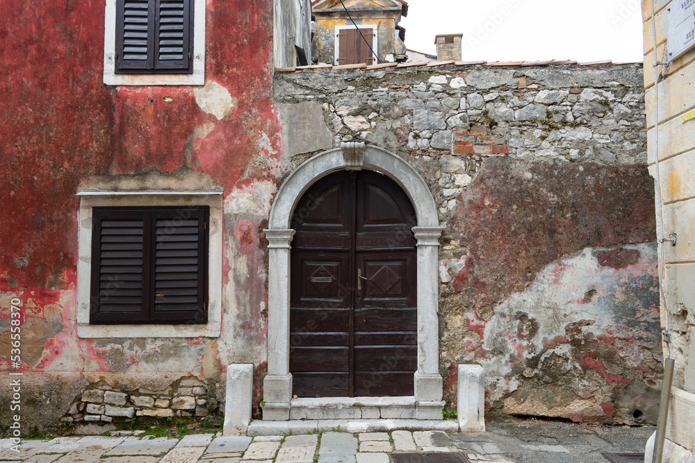 An old doorway next to a red wall in Porec, Istria, Croatia. An old doorway next to a red wall in Porec, Istria, Croatia.