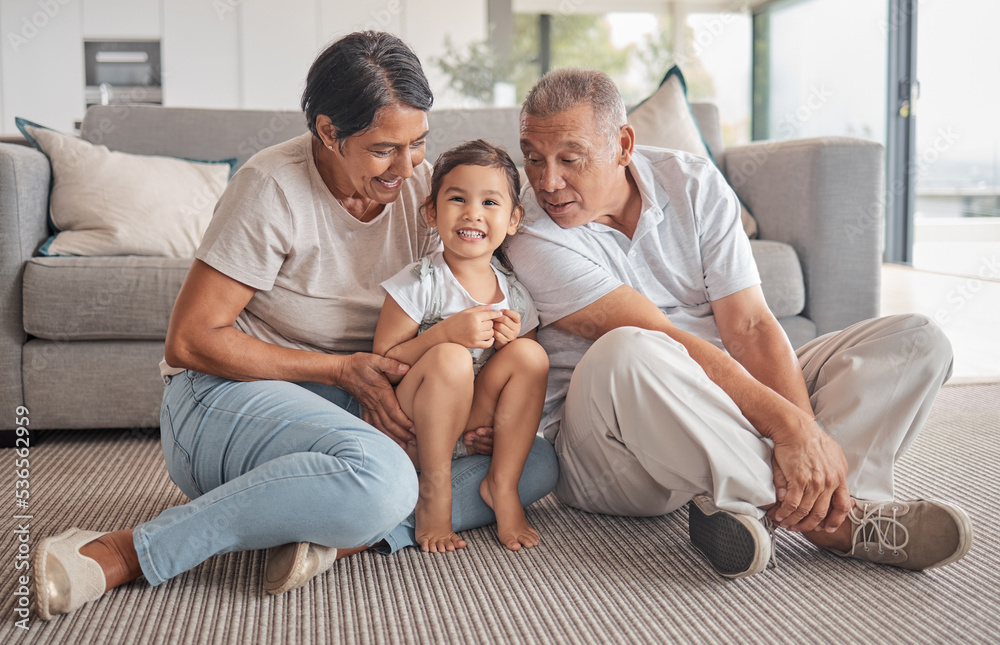 Grandparents, little girl and love in relaxing bonding time together in the living room at home. Portrait of happy child smiling in loving, fun relationship with grandma and grandpa relaxing on floor Grandparents, little girl and love in relaxing bonding time together in the living room at home. Portrait of happy child smiling in loving, fun relationship with grandma and grandpa relaxing on floor