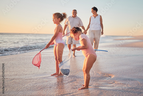 Sticker Grandparents and children at the beach with fishing nets and having fun