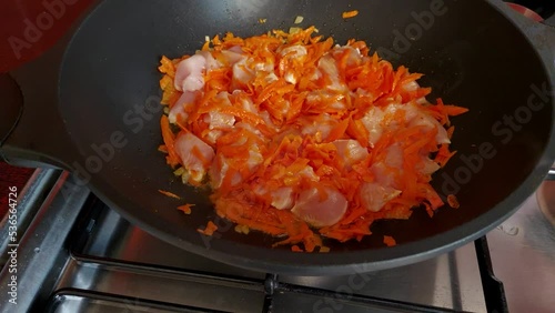 cooking chicken with vegetables. chicken and vegetables fried in a frying pan
