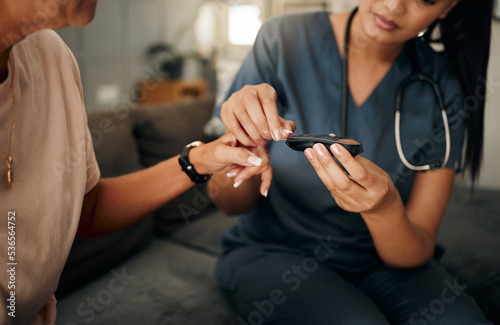 Diabetes  nurse and glucometer with patient in home checking blood sugar levels. Healthcare  health and medical professional with glucose meter to test insulin levels in house checkup for wellness.