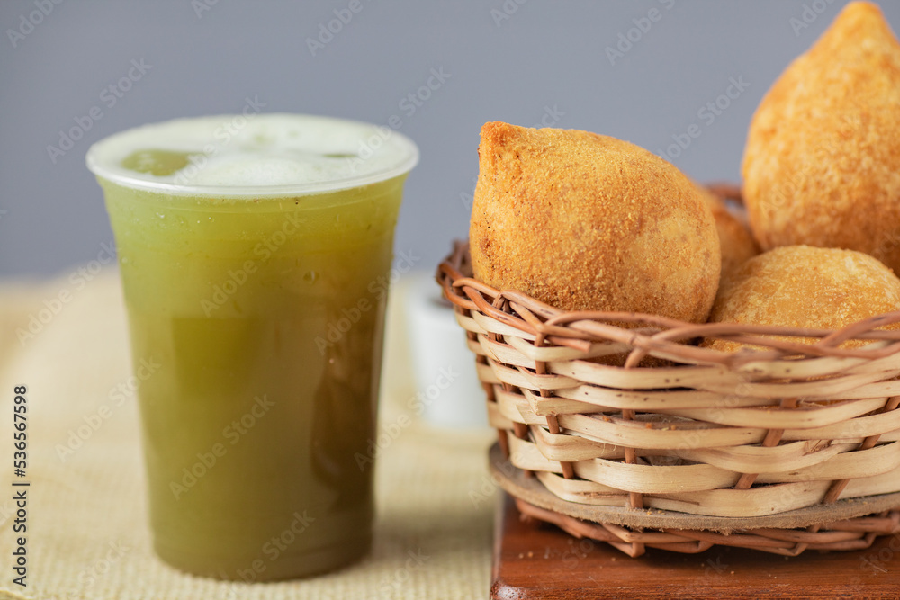 Traditional brazilian snack. Coxinha of chicken and cane juice.
 - obrazy, fototapety, plakaty 