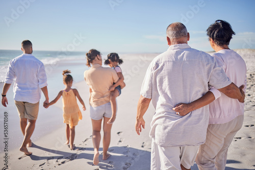 Big family at beach, relax on summer vacation with grandparents and kids at the sea. Retirement time together, quality travel in the sun and enjoy a holiday by the ocean. Sand, sunshine and fresh air